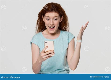 excited woman holding phone looking at cellphone surprised by sms stock image image of reading