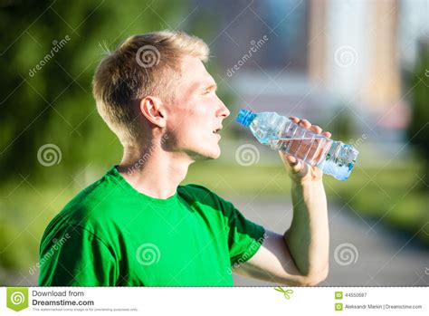 Tired Man Drinking Water From A Plastic Bottle After Fitness Stock