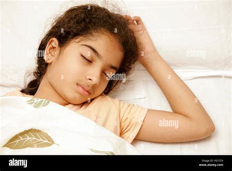 south asian indian 9 years old girl wearing peach colour nightwear having sound asleep on bed mr