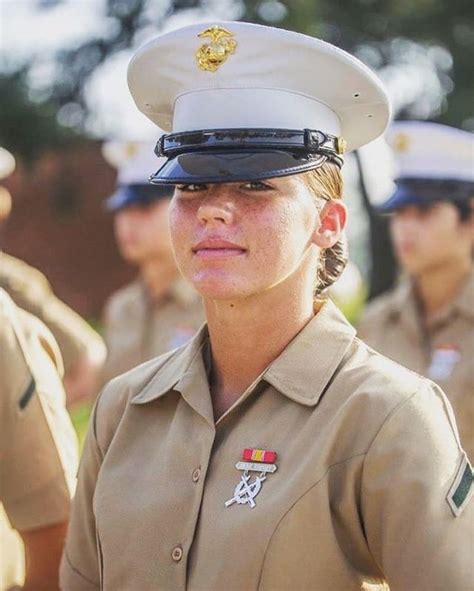 A Woman In Uniform Standing Next To Other Uniformed People And Looking