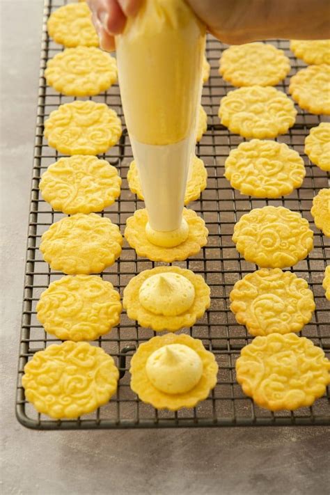 Someone Is Making Cookies On A Cooling Rack With Icing Being Poured Onto The Top