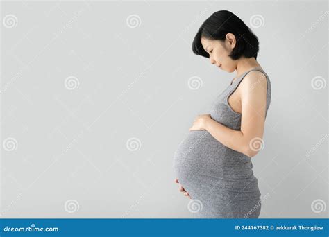 Gravid Asiatisk Kvinna Som Står Och Vidrör Stor Mage Med Händerna