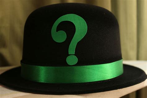 A Black Hat With A Green Question Mark On It