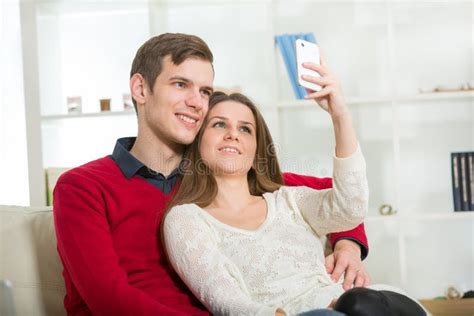 Smiling Couple Taking Self Portrait Picture With Telephone At Home Stock Image Image Of