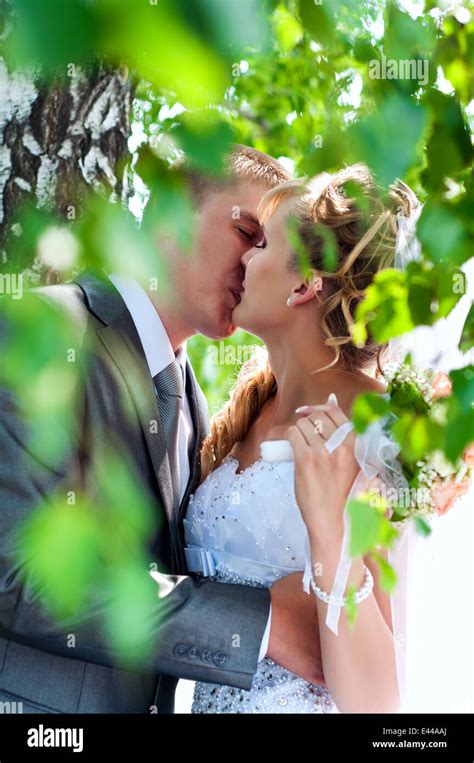 Caucasian Newlywed Couple Is Kissing Under The Tree Stock Photo Alamy
