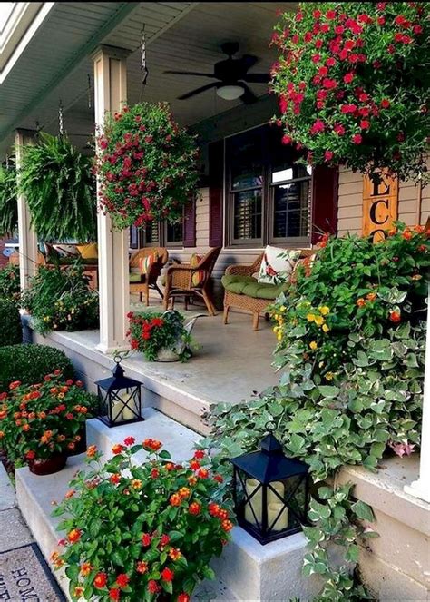 The Front Porch Is Decorated With Flowers And Potted Plants