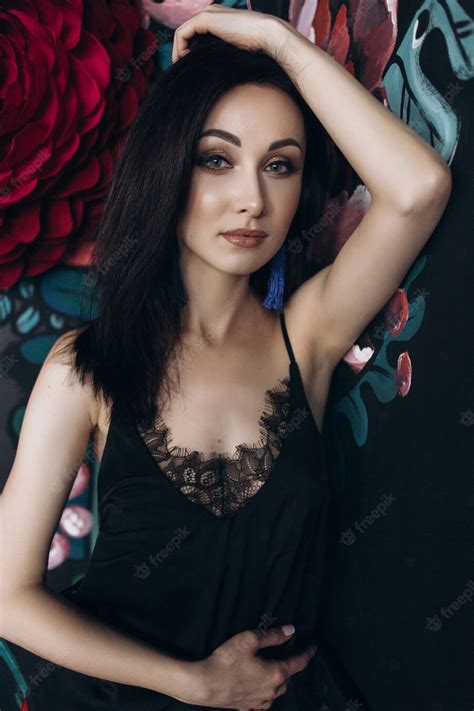 Free Photo Seductive Woman In Black Lingerie Poses Before Large Colorful Flowers