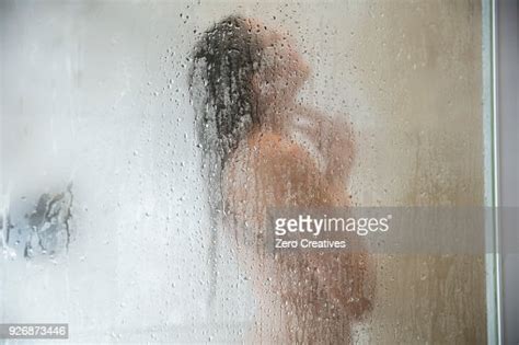 Young Woman In Shower Behind Steamed Glass Door ストックフォト Getty Images