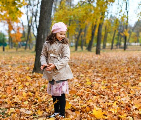 Girl Playing With Fallen Yellow Leaves Portrait Of A Happy Child In An