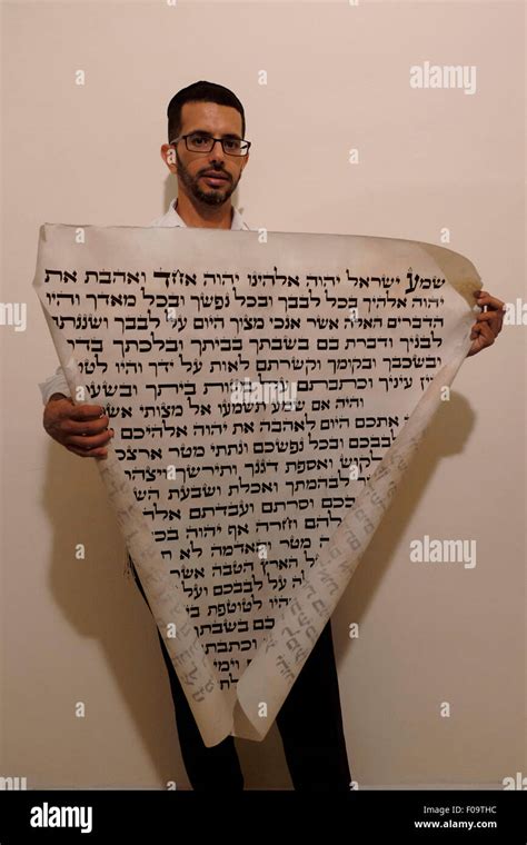 A Religious Jewish Man Holds A Parchment Of A Huge Mezuzah Inscribed