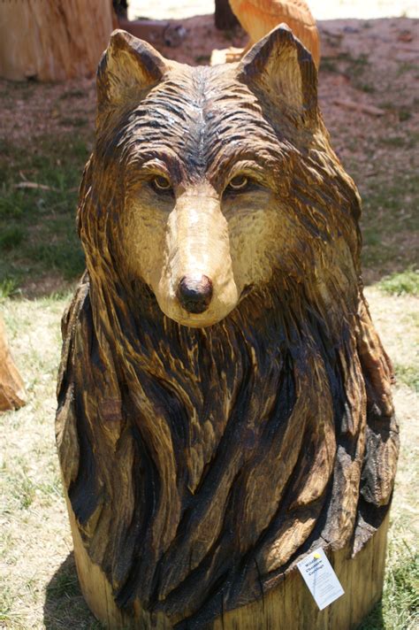 A Bear Statue Sitting On Top Of A Wooden Stump