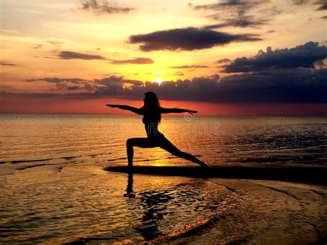 Silhouette Of A Girl Practicing Yoga On The Beach Shooting Against The