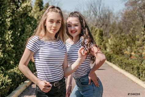 Two Smiling Young Female Girl Friends Having Fun In Park Stock Photo