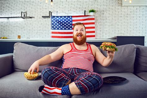 Overweight Funny Man Eating A Burger Snacking While Sitting On The