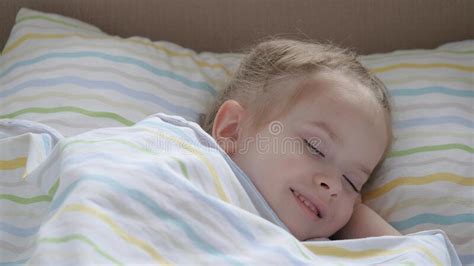 Happy Baby Sleeps In A Baby Bed And Smiles Mom Put Her Tired Daughter
