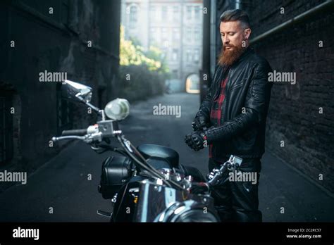 Bearded Biker In Leather Clothes Against His Chopper Vintage Bike