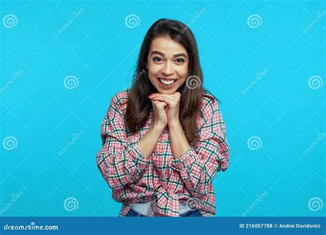 Optimistic Smiling Girl Clasps Hands Near Face Smiles Broadly Dressed In Casual Clothes