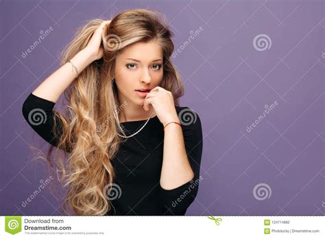 Beautiful And Seductive Blonde Girl Touching Long Volumed Hair And Posing Stock Photo Image