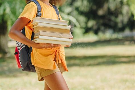 View Of African American Schoolgirl With Backpack Holding Books Stock