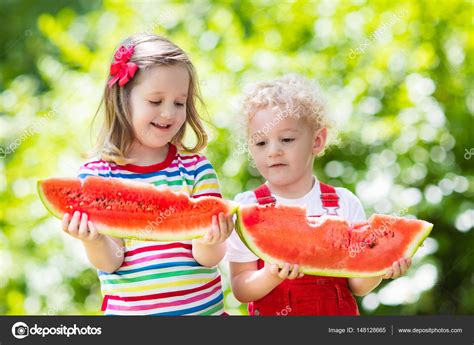Kids Eating Watermelon In The Garden — Stock Photo © Famveldman 148128665