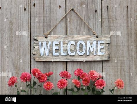 Rustic Welcome Sign Hanging On Weathered Wood Fence With Autumn Flower