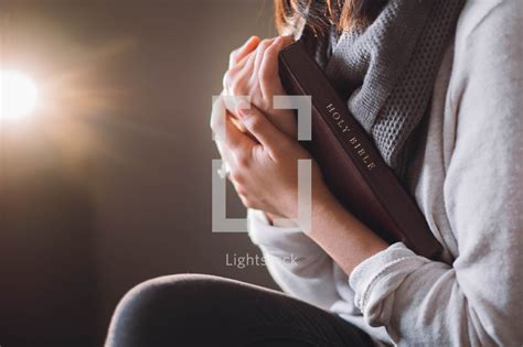 A Woman Holding A Bible Close To Her Heart — Photo