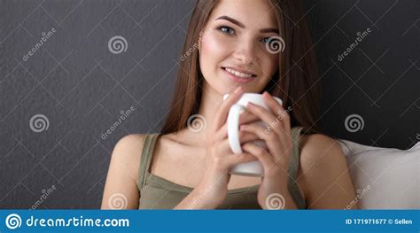 A Beautiful Young Healthy Sitting On The Floor With A Cup Of Tea Or