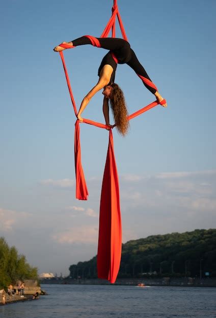 premium photo beautiful and flexible female circus artist dancing with aerial silk with sky
