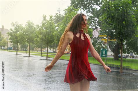 Attractive Young Happy Girl Dancing And Smiling In The Rain Wearing