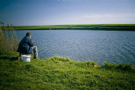Pesca Del Hombre En La Orilla Del Lago Foto De Archivo Imagen De