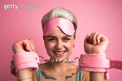 Overjoyed Female Person Posing In Handcuffs Enjoys Physical Restrains