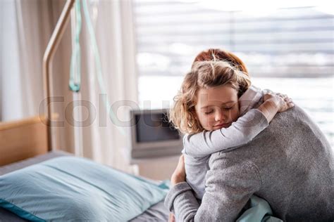 Caring Mother Visiting Small Girl Daughter In Hospital Hugging