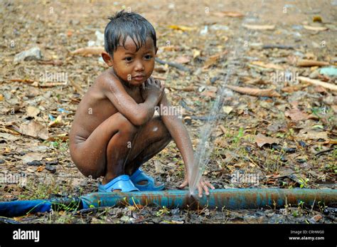 Peu De Fun Garçon Jouant Avec Un Tuyau Deau Dégradé Cambodge Banque D