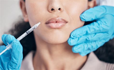 Shot Of A Young Woman Having Filler Injected Into Her Face Stock Photo
