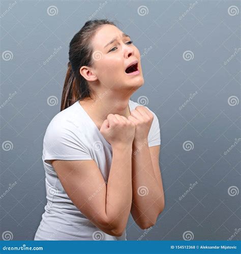 Woman Praying About Something Or Begging For Mercy Against Gray Background Stock Photo Image