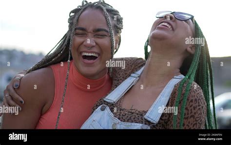Two Hispanic Black Women Embrace South American Brazilian Sisters Hugging Posing Outdoors