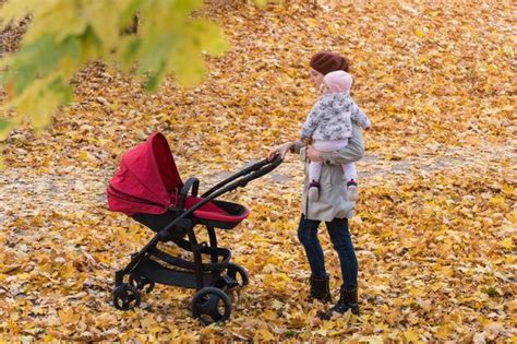 Premium Photo Mom Walks In Autumn Park With Baby Stroller Mother And