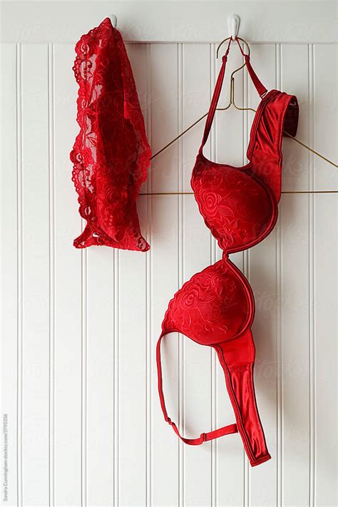 Closeup Of Red Lace Bras And Panties Hanging On Hooks By Stocksy