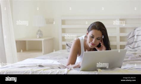 Young Woman Laying Down In Bed Using Laptop Stock Photo Alamy