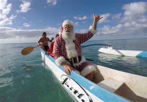 Santa Waves To Surfers As He Goes Outrigger Canoe Surfing Off Waikiki