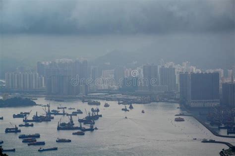 High Modern Buildings In Fog And Thick Rain Clouds Of Hong Kong Harbor