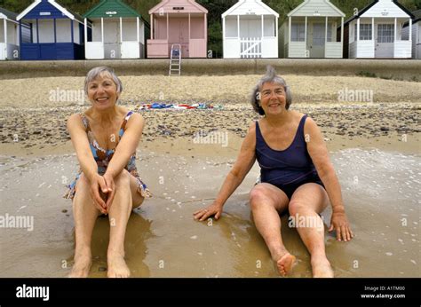 Southwold Suffolk Uk Elderly Women On Sitting On Beach In Swimming Costumes Stock Photo