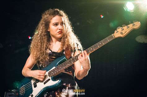 A Woman With Long Hair Playing A Bass Guitar