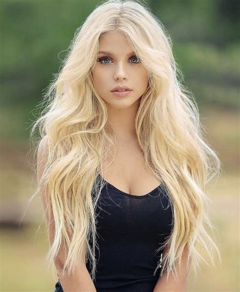 A Woman With Long Blonde Hair Is Posing For The Camera