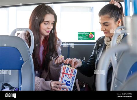 Dos Amigos Disfrutando De Palomitas En El Asiento Trasero De Un Autobús