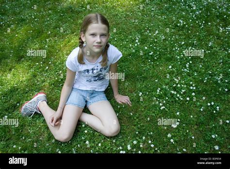 Junges Mädchen sitzen auf Wiese voller Gänseblümchen Stockfotografie Alamy