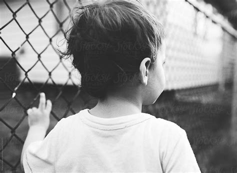 Boy Leans Against Fence By Stocksy Contributor Maria Manco Stocksy