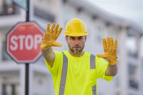 Premium Photo Worker Builder In Hard Hat With Stop Road Sign Builder