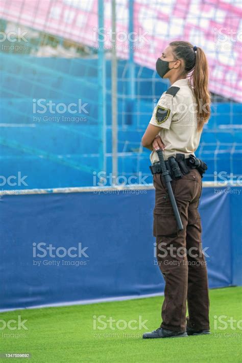 Female Security Guard Visually Surveying At An Outdoor Event Stock