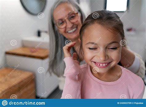Happy Senior Grandmother And Granddaughter Standing Indoors In Bathroom